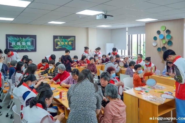 志愿者与残障老人一起编织二十四节气团扇。学校供图